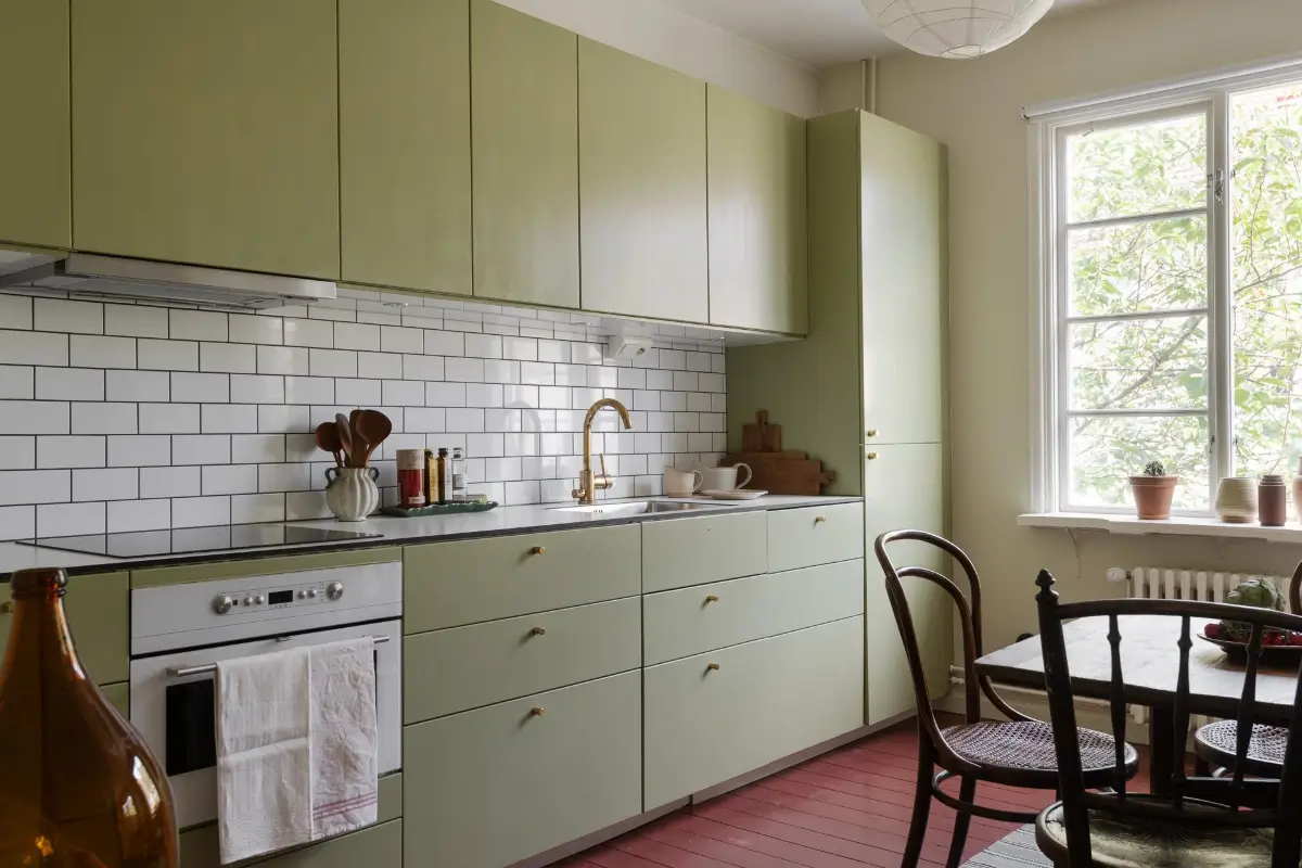 Historic Character and Color in a Swedish Studio Apartment 14 green kitchen cabinets red painted floorboards