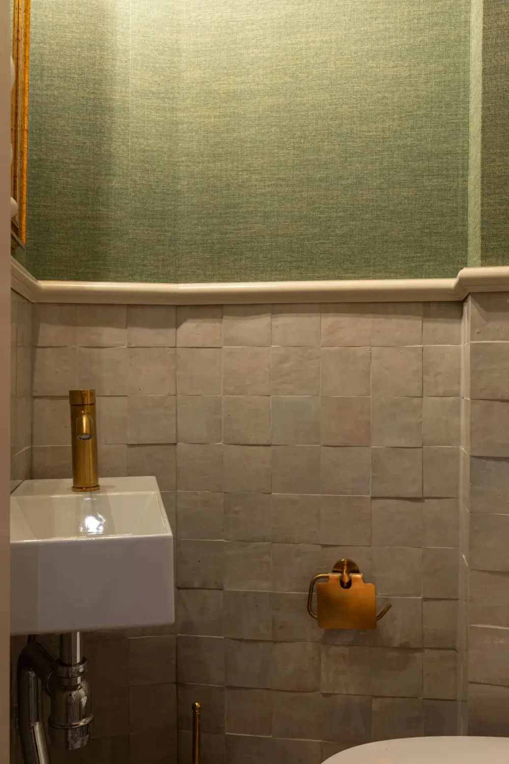 A Luxurious Family Apartment with a Dramatic Black Bathroom 35 guest toilet zellige tiles green wallpaper brass fittings