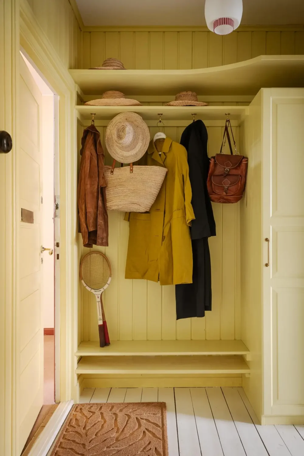 Historic Character and Color in a Swedish Studio Apartment 25 hall hat shelf storage wardrobe yellow tongue and groove paneling