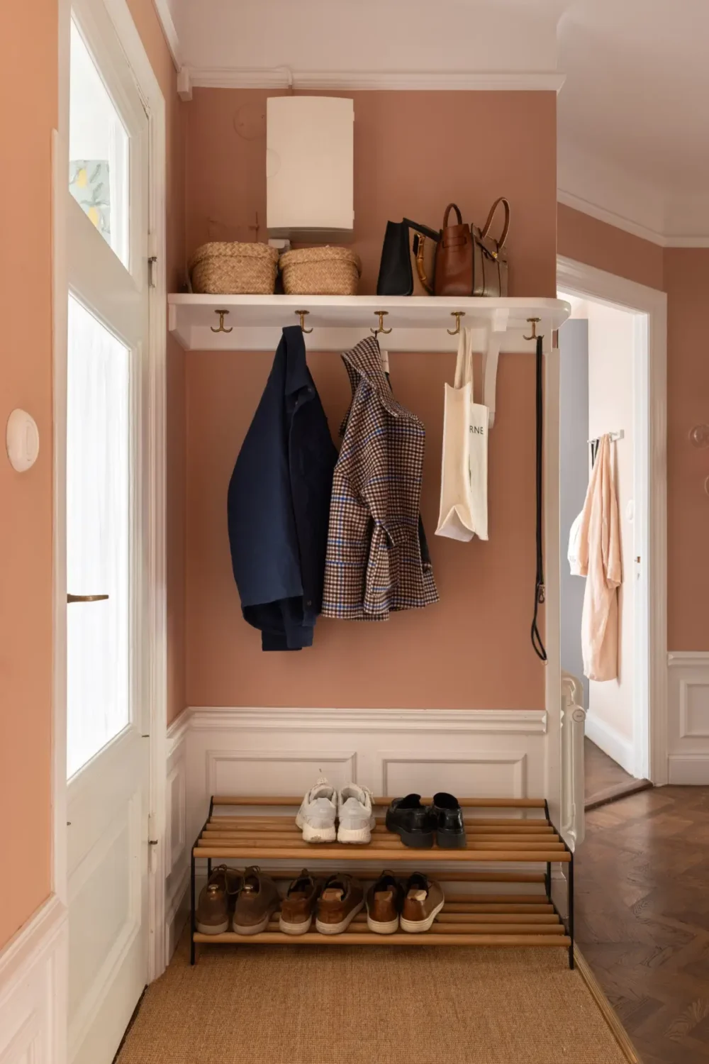 A Warm Color Palette in a Cozy 1920s Apartment in Stockholm 30 hall hat shelf terracotta wall color A Warm Color Palette in a Cozy 1920s Apartment in Stockholm