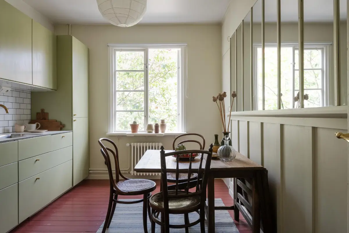Historic Character and Color in a Swedish Studio Apartment 13 kitchen red-painted floorboards green cabinet doors