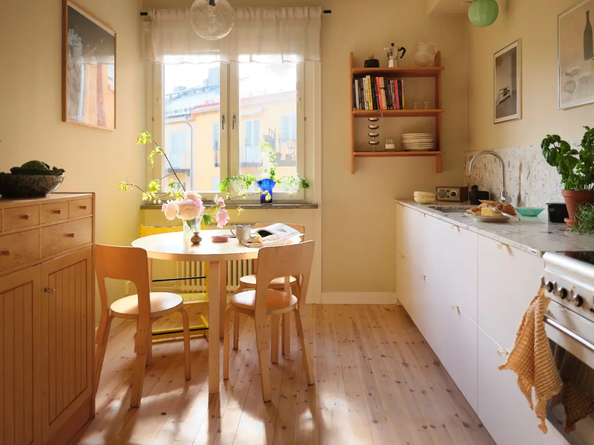 Soft Beige Interiors with the Occasional Bright Color Pop in Stockholm 11 kitchen white cabinets terrazzo countertop round table