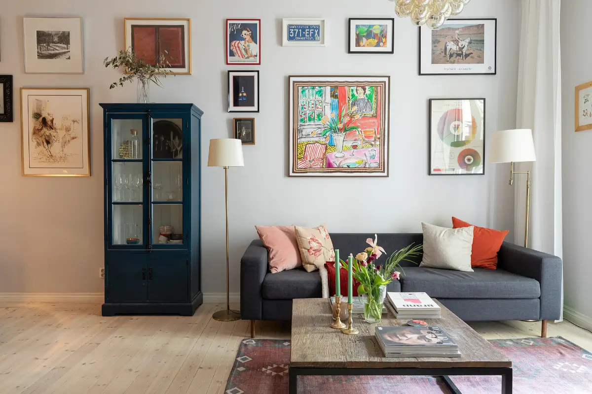 Red and Blue Color Accents in an Open-Plan Stockholm Apartment 3 light gray living room gallery wall