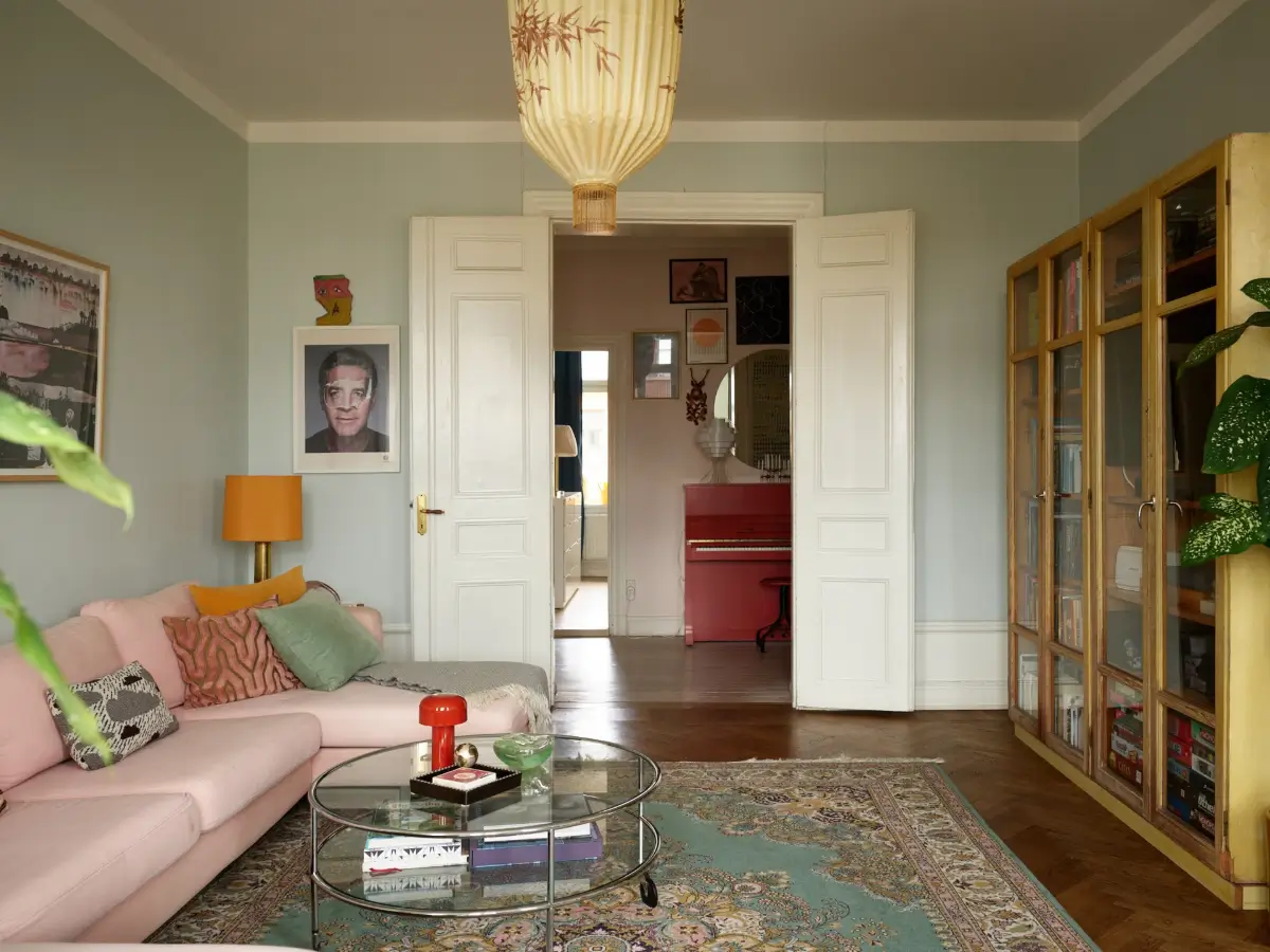 A Spacious Family Apartment with Original Details in Stockholm 6 living room light blue walls pink sofa