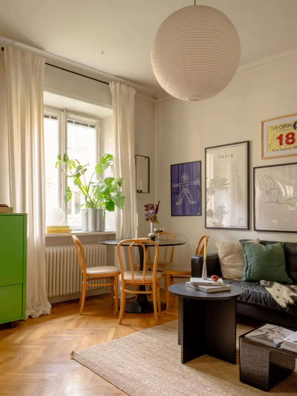 A 1920s Studio Apartment with a Forest Green Sleeping Alcove 4 sitting room round black table