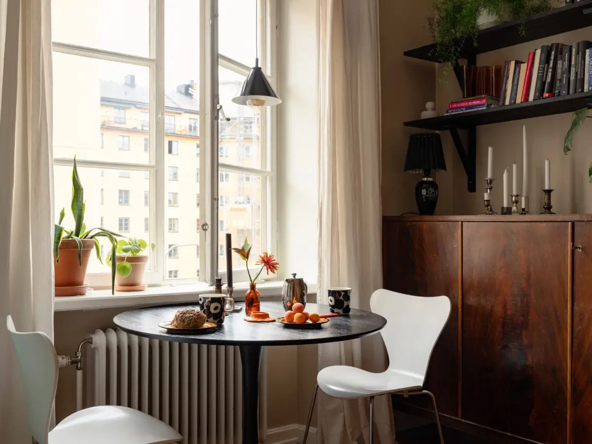 Warm Beige Walls and Practical Niches in a 1920s Studio Apartment 7 studio round dining table