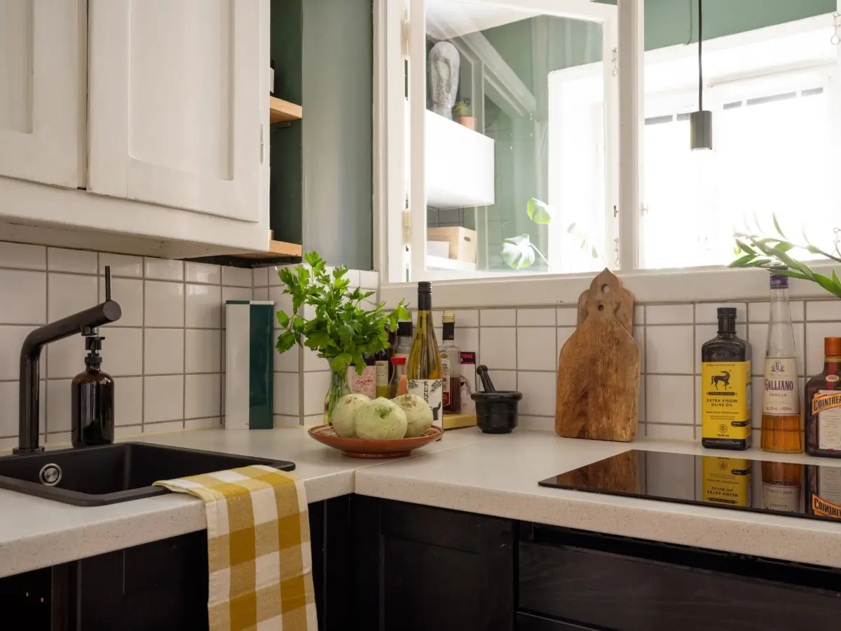 A 1920s Studio Apartment with a Forest Green Sleeping Alcove 16 tiny kitchen black and white cabinets