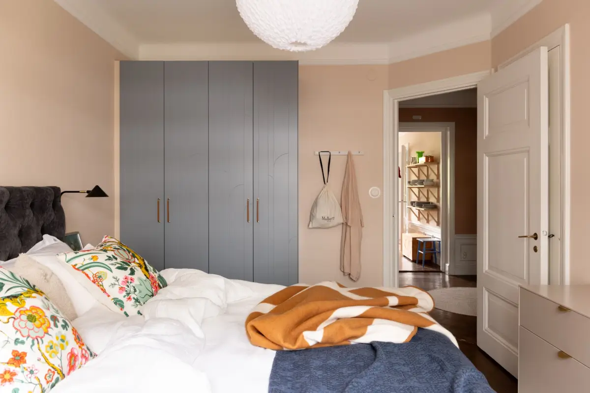 A Warm Color Palette in a Cozy 1920s Apartment in Stockholm 23 warm beige bedroom blue wardrobes