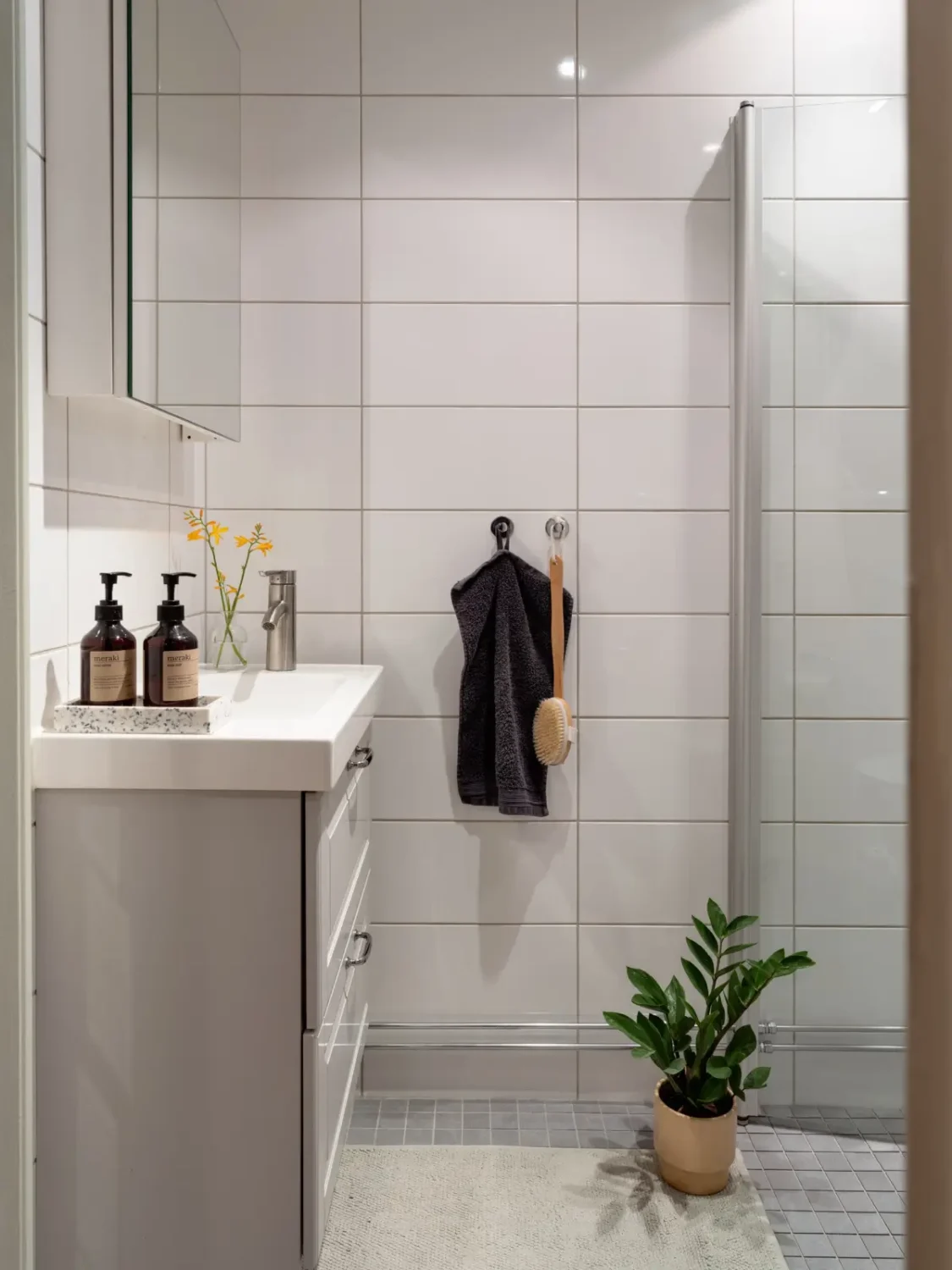 A Light Color Palette and a Charming Private Patio in a Stockholm Apartment 29 white tiled bathroom