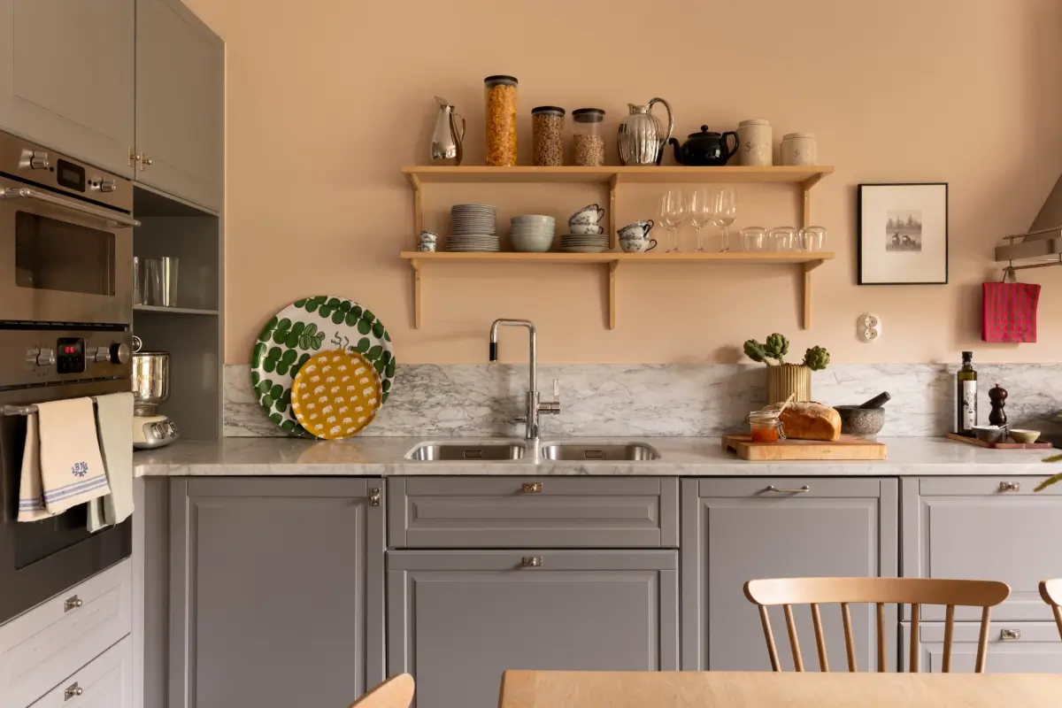A Warm Color Palette in a Cozy 1920s Apartment in Stockholm 2 wooden shelves gray cabinets