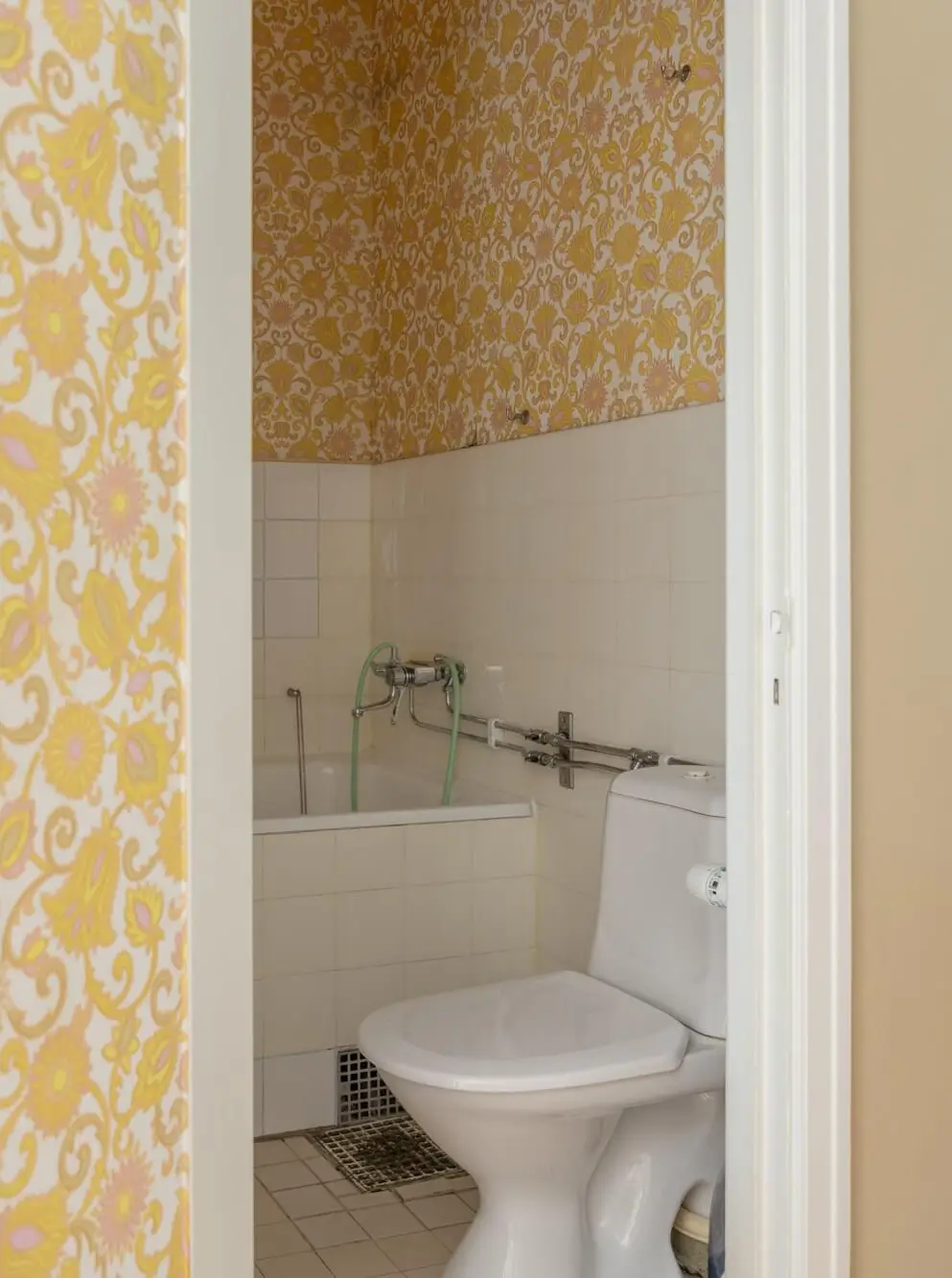 Warm Tones, Antiques, and Period Features in a Swedish Studio Apartment 19 yellow wallpaper bathroom