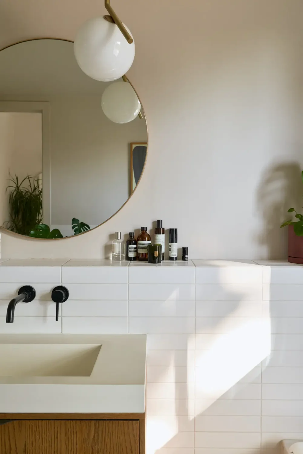 A Beautiful Victorian Townhouse Reimagined for Modern Living 34 bathroom white tiles large round mirror