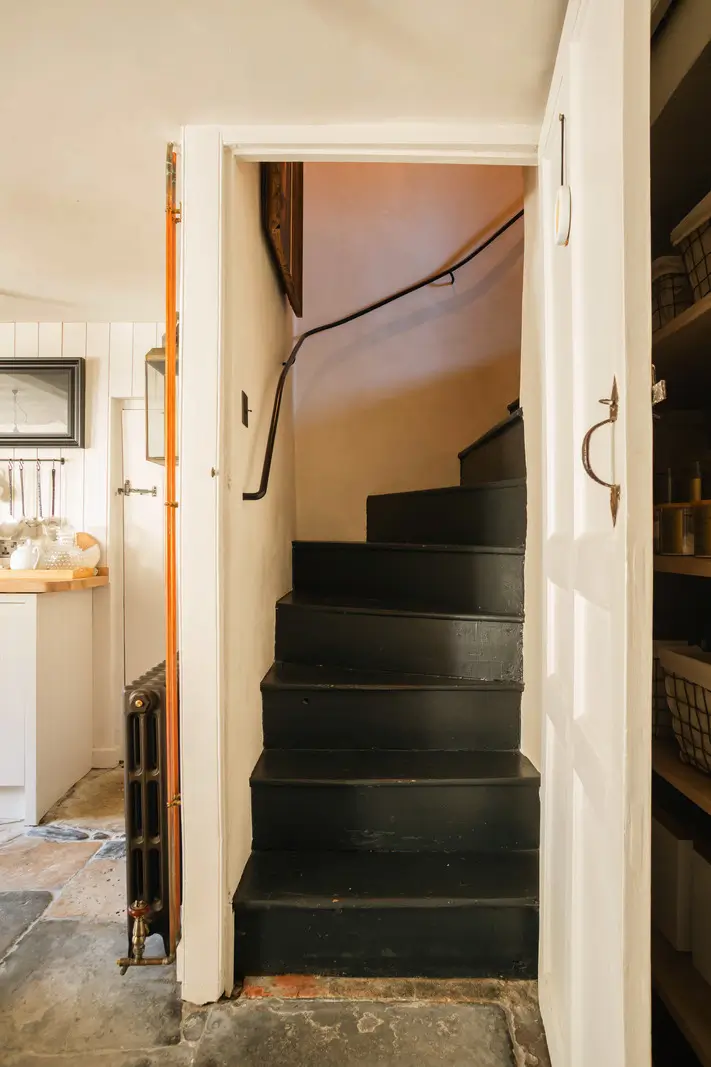 Lime Paint and Cozy Rooms in a Charming English Cottage 9 black wooden staircase