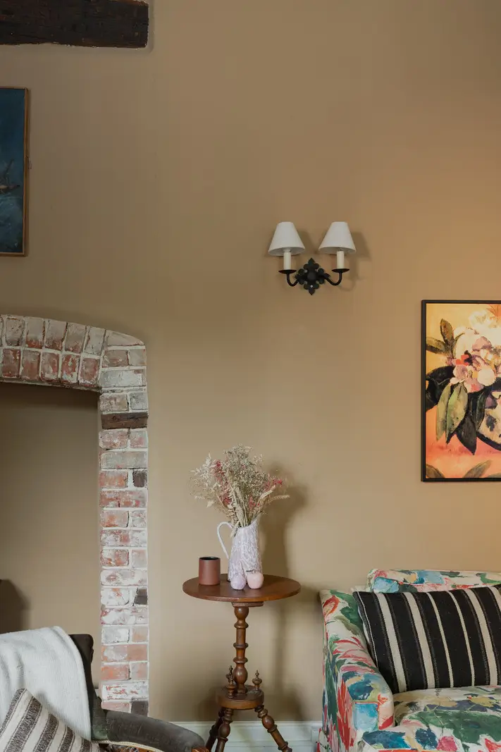 A Charming English Cottage with a Sage-Green Kitchen 3 brick fireplace