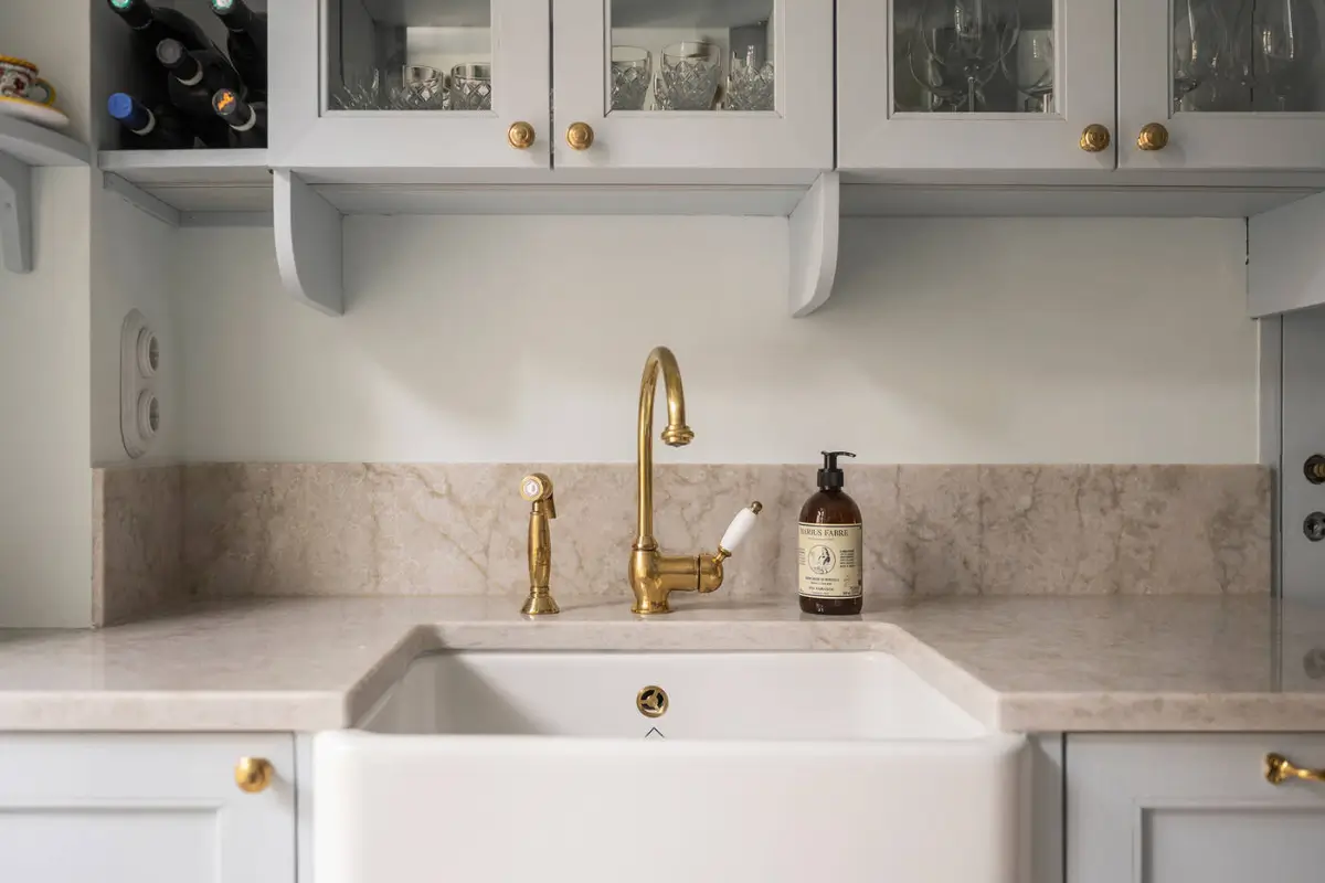 A Stylish Beige Apartment with a Light Blue Kitchen 13 butler sink brass faucet