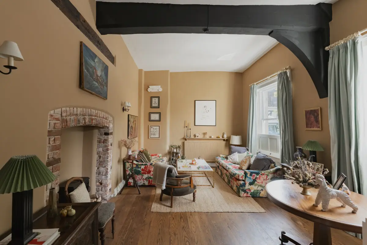 cottage living room beige-yellow walls brick fireplace floral sofas nordroom