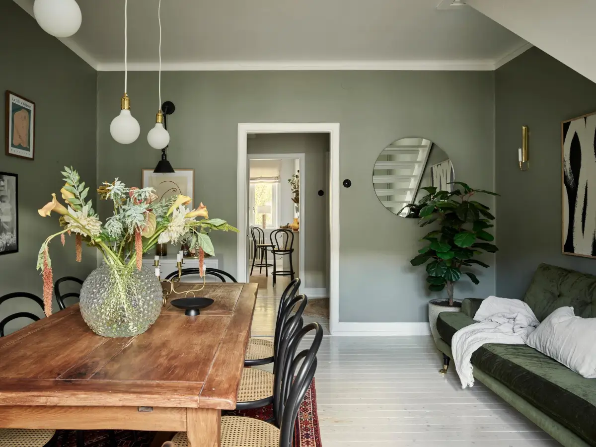 Gray Tones and High Ceilings in a Cozy Swedish Duplex Apartment 26 dining room gray-green walls rustic table green sofa