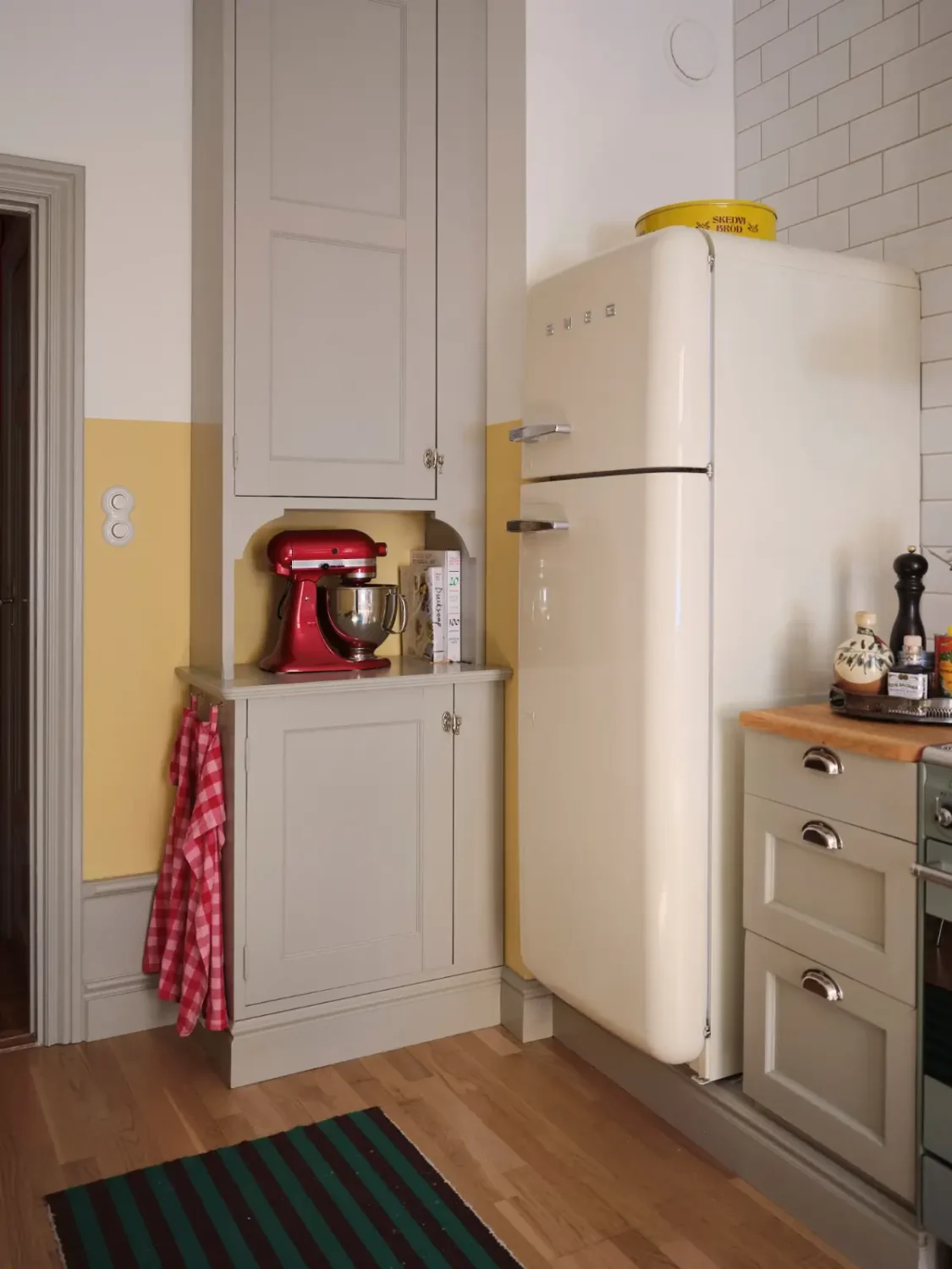 Color, Books, and a Walk-In Wardrobe in a Small Stockholm Apartment 10 gray kitchen cabinets white smeg fridge nordroom