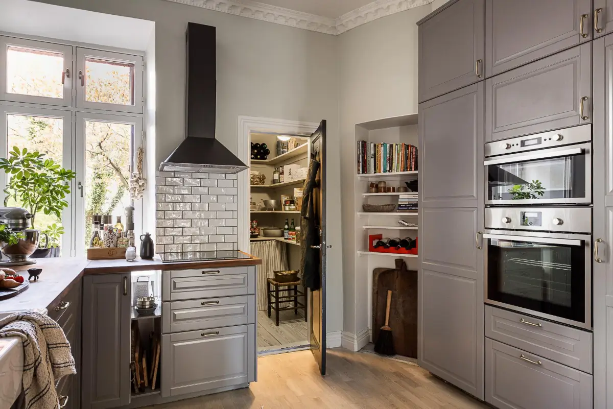 Warm Neutral Tones and Period Features in a Swedish Apartment 19 gray kitchen with pantry and built-in shelves