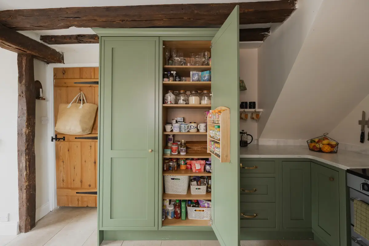 A Charming English Cottage with a Sage-Green Kitchen 10 kitchen pantry cabinet