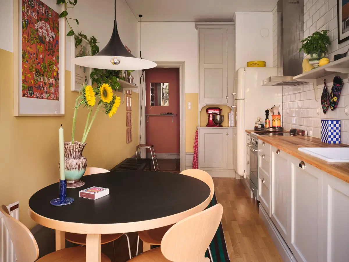 Color, Books, and a Walk-In Wardrobe in a Small Stockholm Apartment 8 kitchen round table half-painted yellow walls nordroom