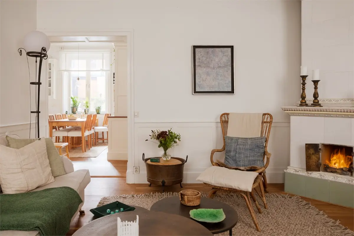 A Light-Filled Stockholm Apartment with a Charming Kitchen 15 living room wicker chair fireplace