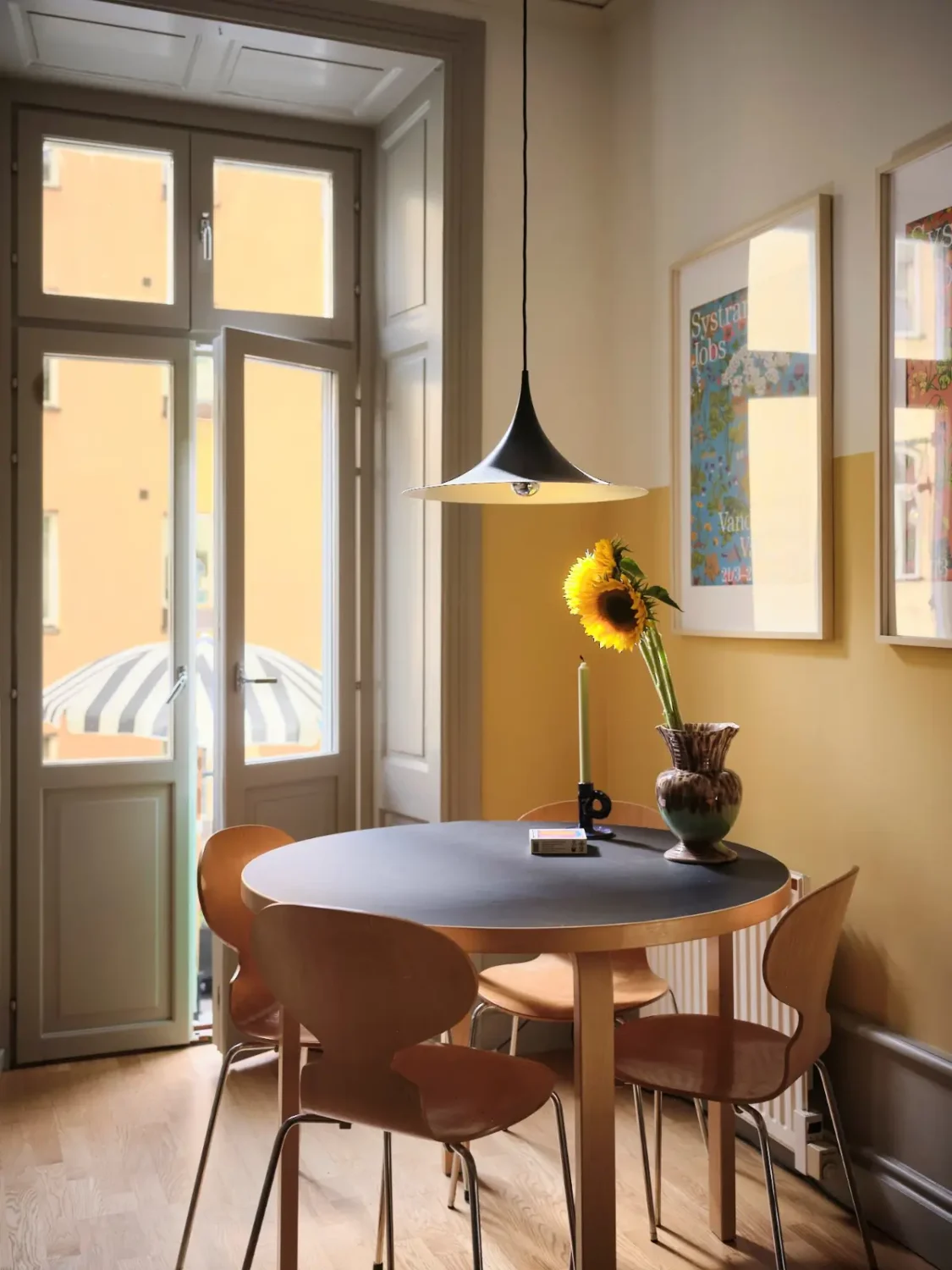 Color, Books, and a Walk-In Wardrobe in a Small Stockholm Apartment 3 round-kitchen-table-yellow-walls-nordroom