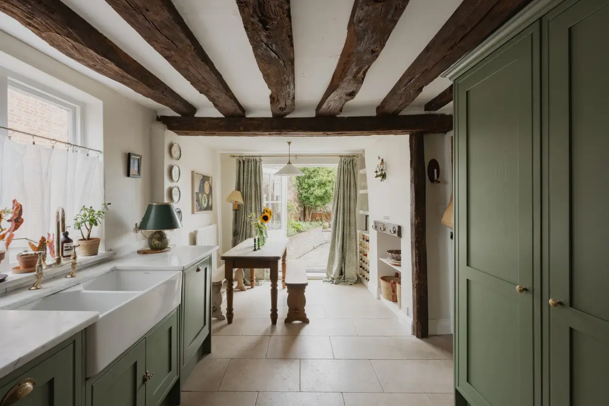 A Charming English Cottage with a Sage-Green Kitchen 5 sage green cottage kitchen wooden beams butler sink wooden table