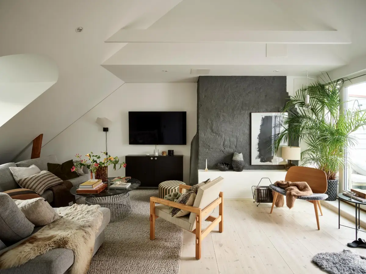 Gray Tones and High Ceilings in a Cozy Swedish Duplex Apartment 1 scandi living room pitched ceiling dark gray accent wall