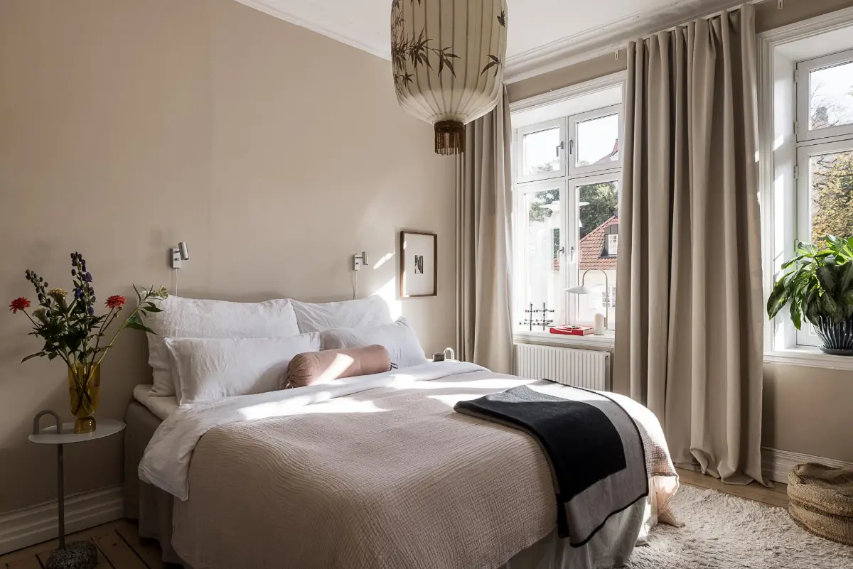 Warm Neutral Tones and Period Features in a Swedish Apartment 14 warm beige bedroom large windows