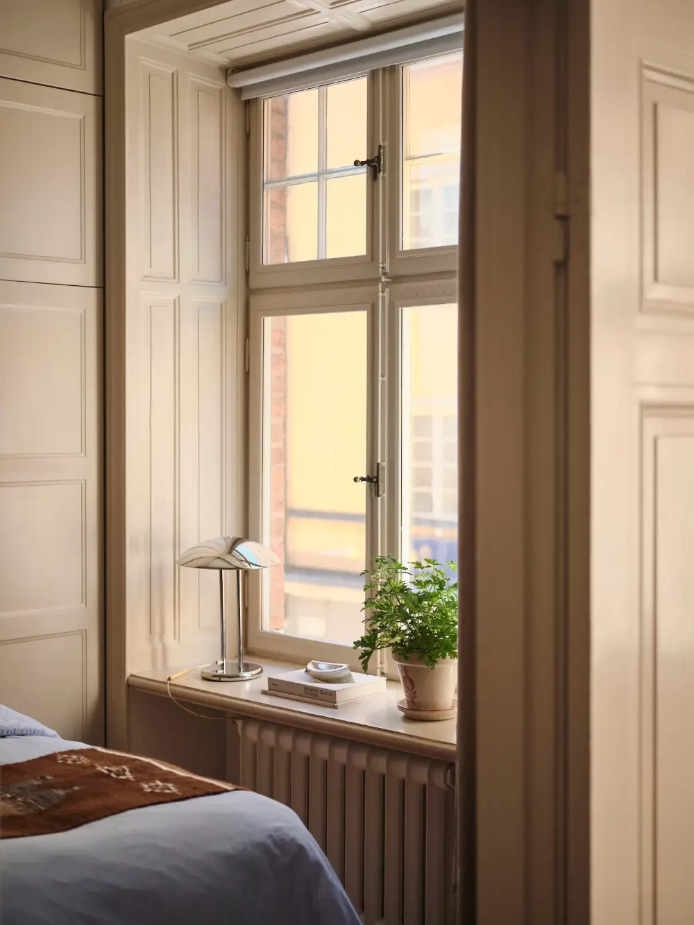 A Decorative Fireplace and Classic Touches in a 592 sq ft Stockholm Apartment 11 large-windows-period-features-renovated-early-20th-century-apartment-nordroom